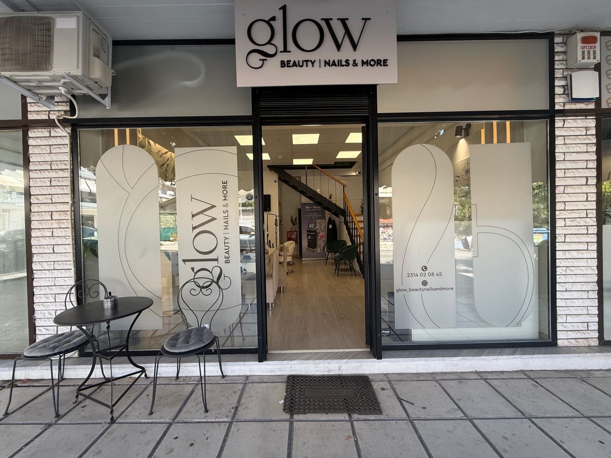 Η πρόσοψη του glow με τη λευκή πινακίδα και τα τζαμωτά με το σήμα του καταστήματος.